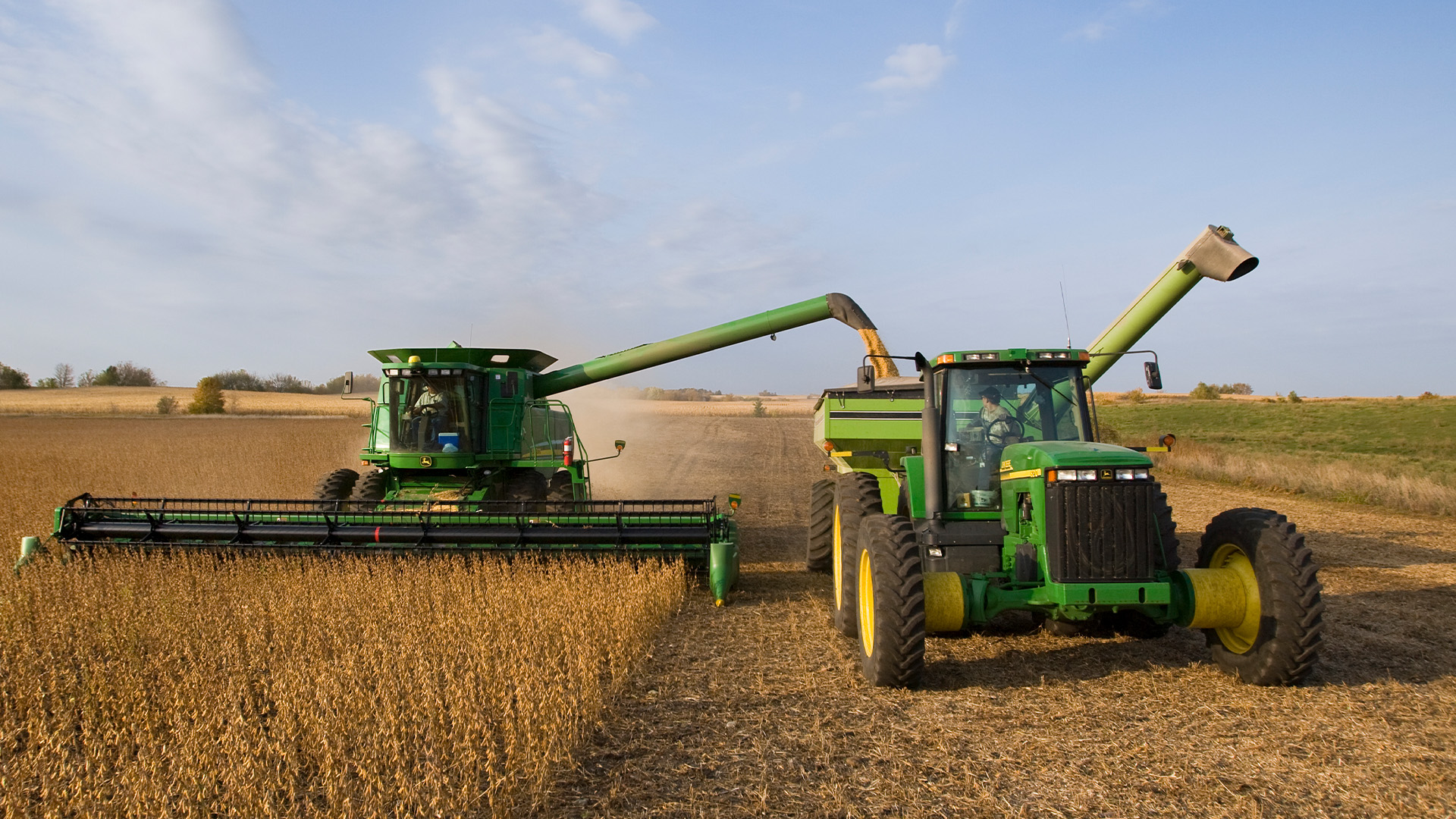 John Deere tractor and combine harvesting grain