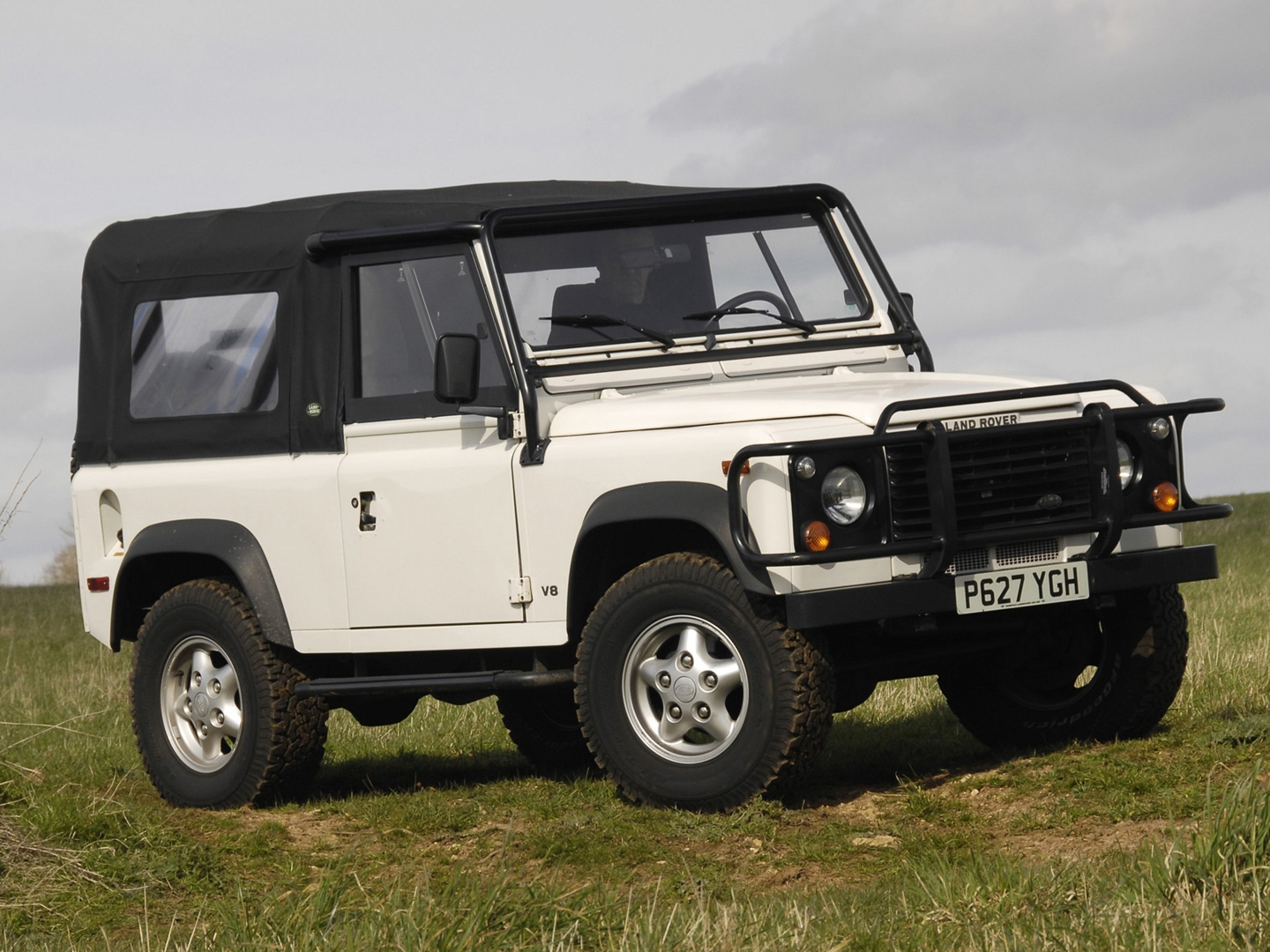 NAS Land Rover Defender in white, soft top on.