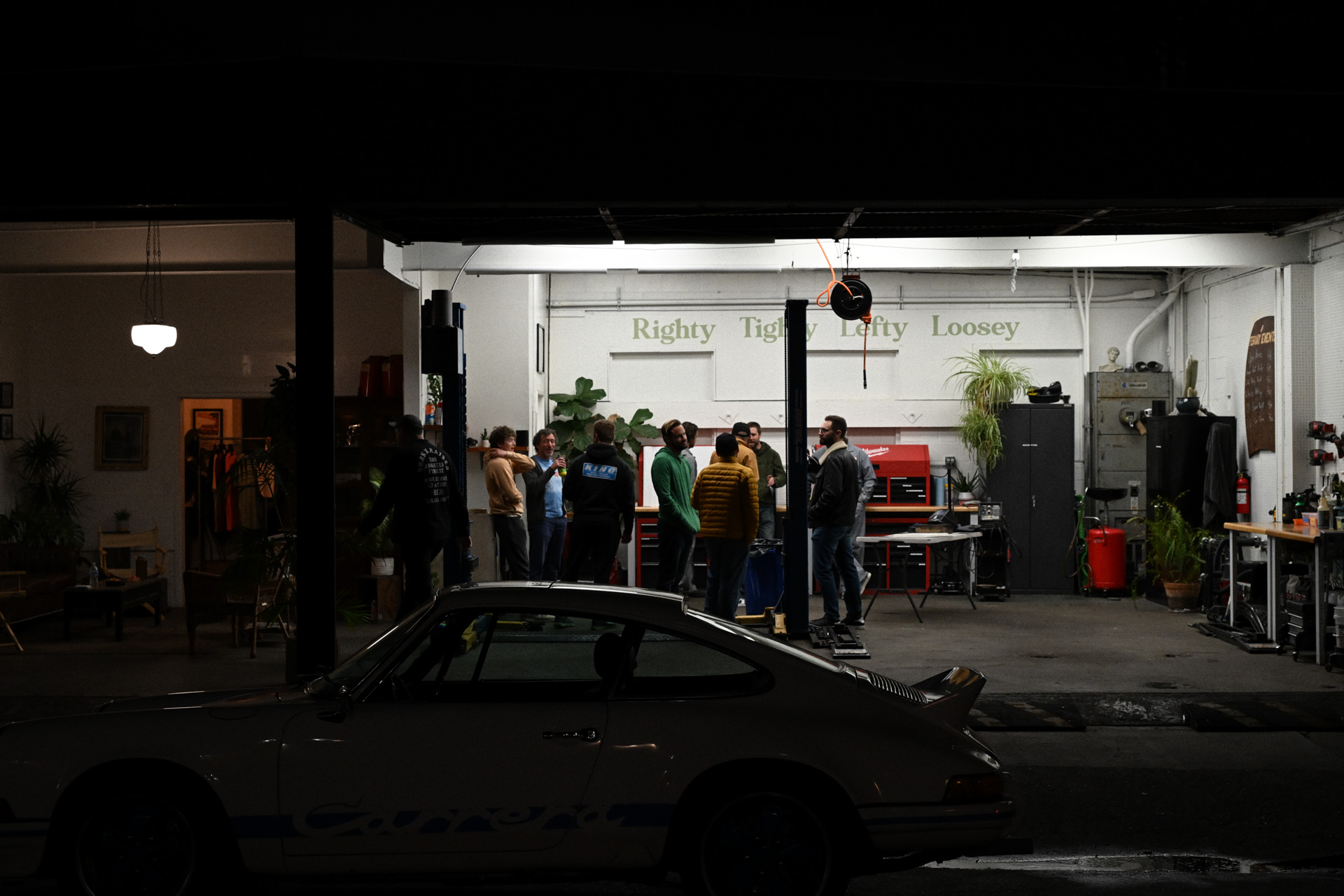 People hanging out in a car garage.