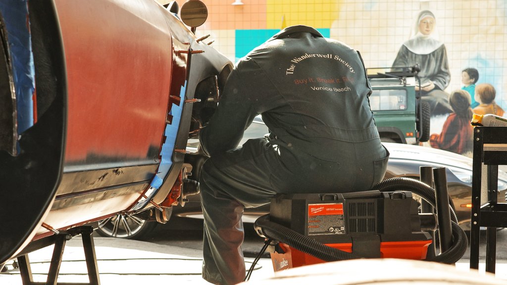 Guy working on a car in a CA shop.