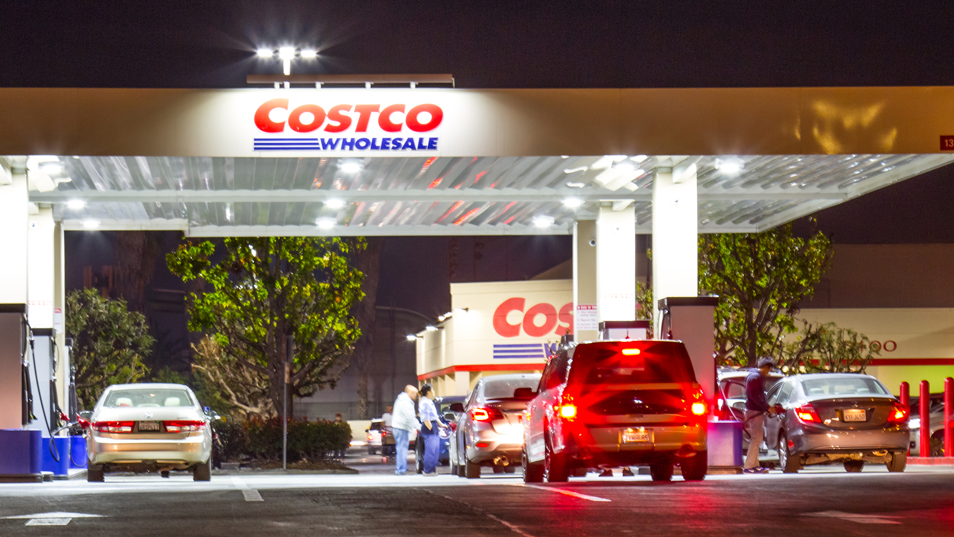 Van Nuys CA USA: November 29 2017: Costco Wholesale storefront in Van Nuys CA at dusk. Costco Wholesale operates an international chain of membership warehouses, carrying brand name merchandise at substantially lower prices. Evening shot of vehicles waiting in multiple lines for the gasoline at Costco, members only, gas station. Costco is known for discounted prices on its merchandise.