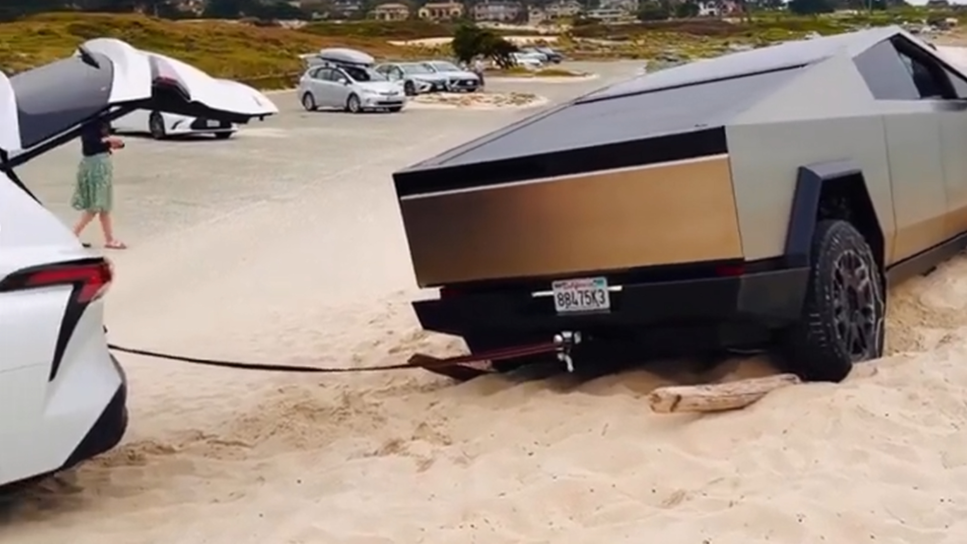 A Toyota Sienna helping a stuck Tesla Cybertruck on a beach