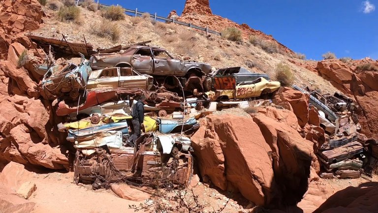 Man climbing Catstair Canyon car pile off Highway 89