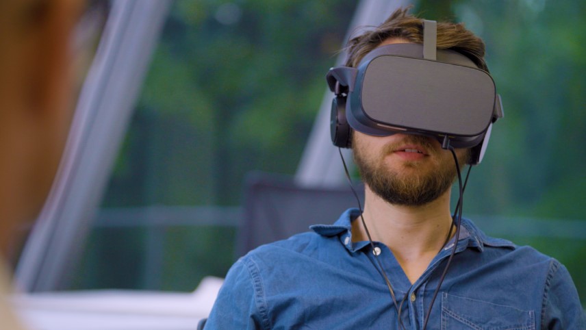Driving instructor in training dons VR headset.