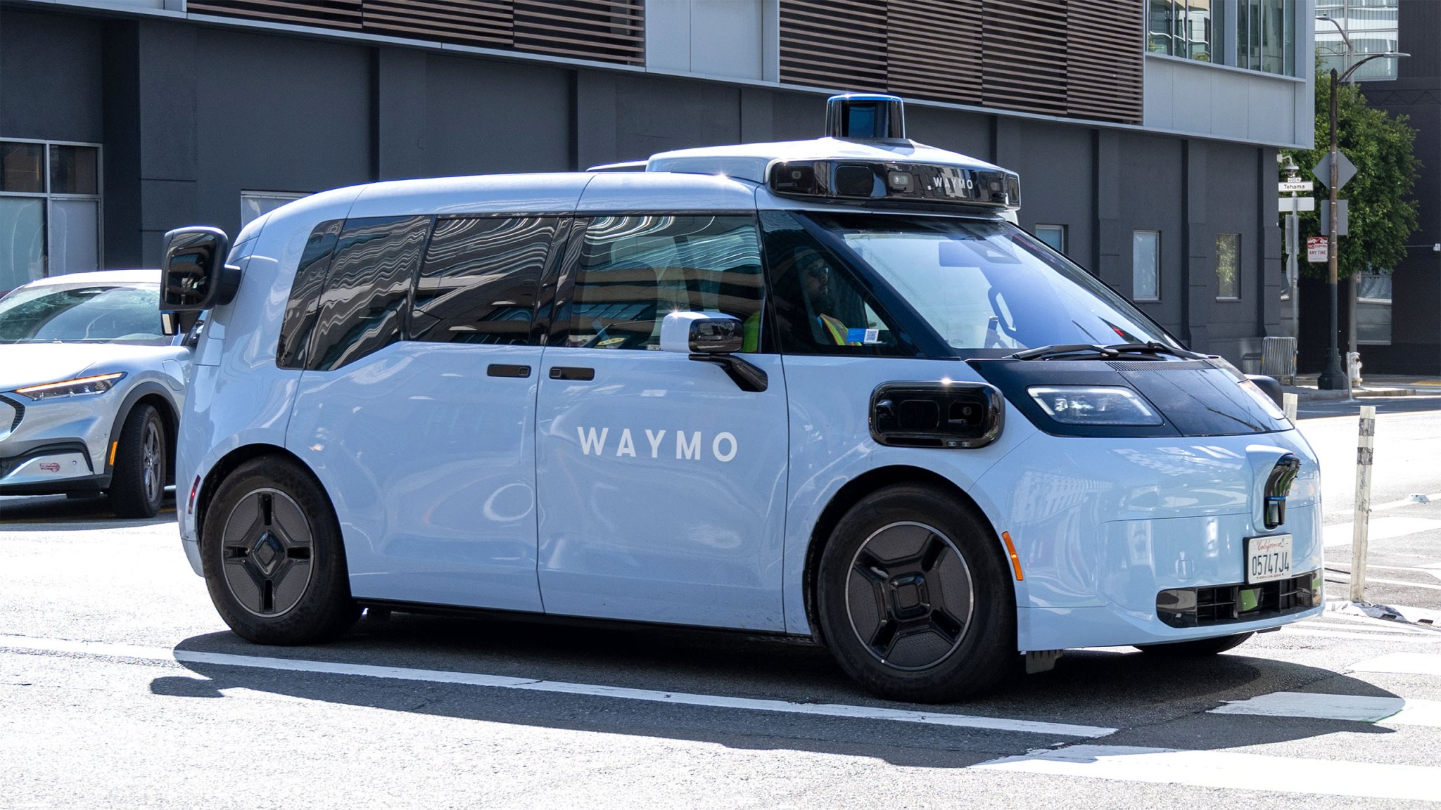 Waymo Zeekr self-driving robotaxi undergoing testing with safety driver visible, San Francisco, California.