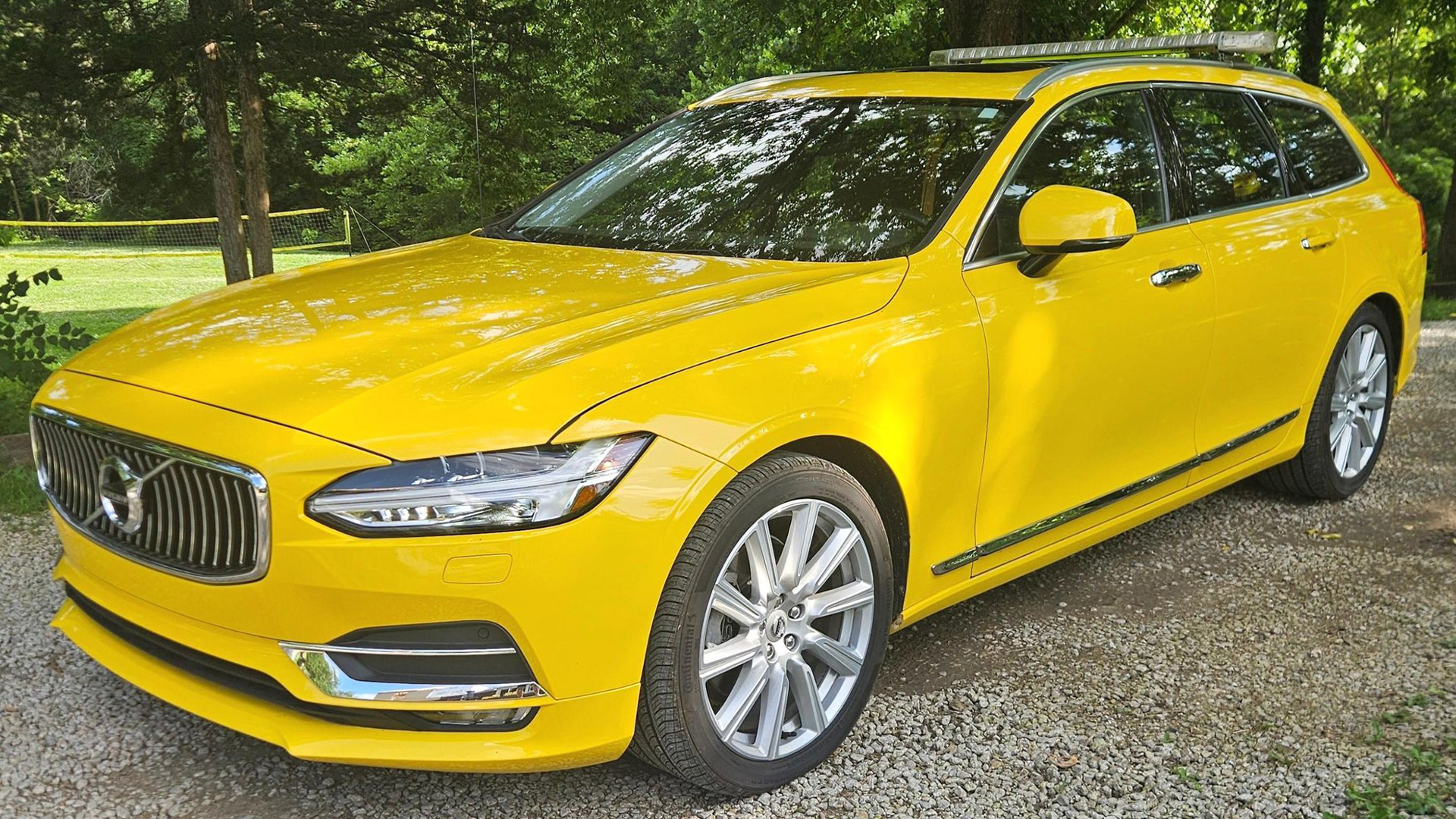 Yellow Volvo V90 with SARSYS airport runway friction testing equipment