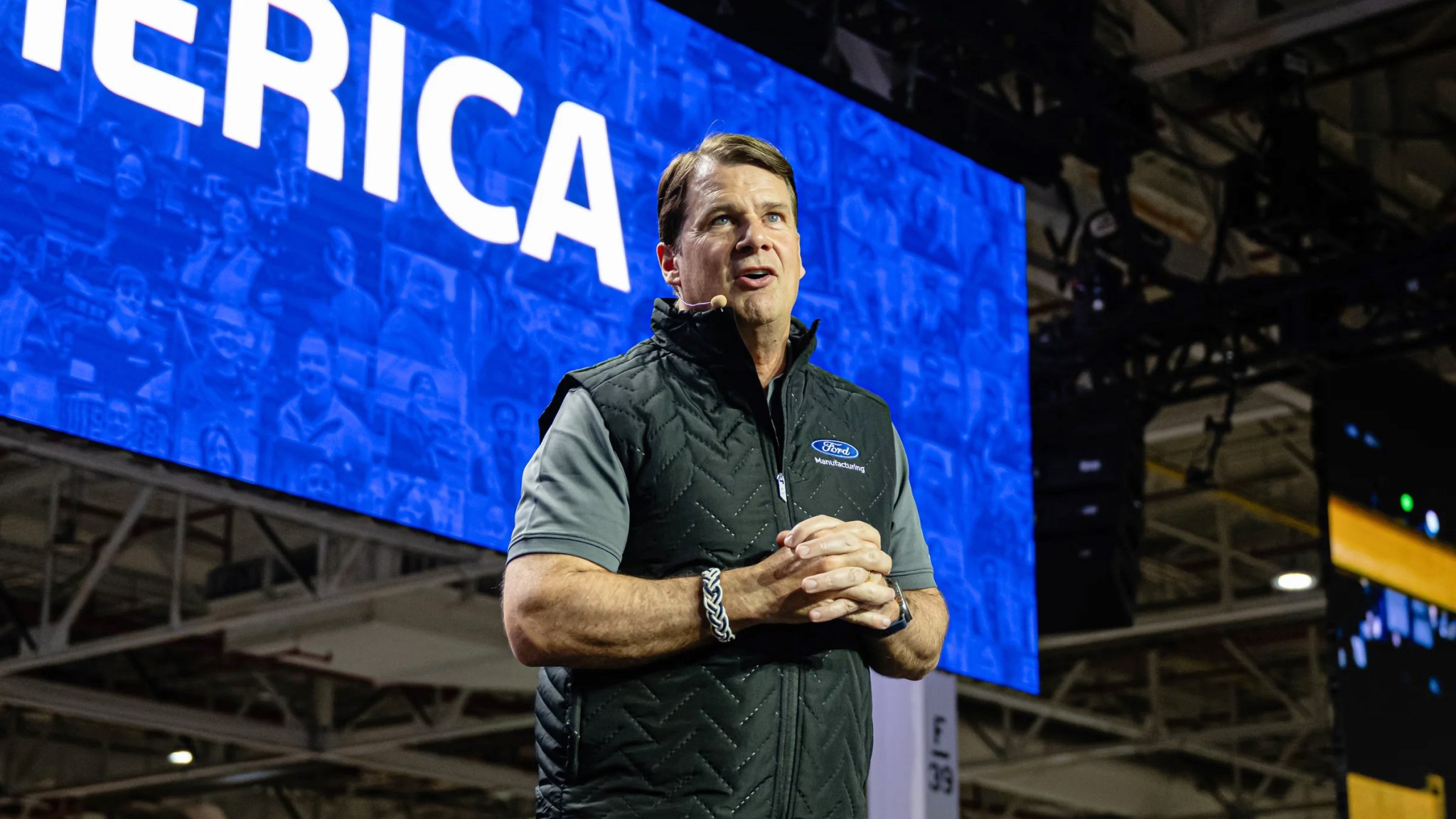 Jim Farley speaks on stage at a Ford plant.
