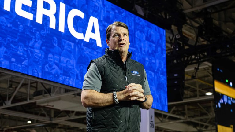 Jim Farley speaks on stage at a Ford plant.