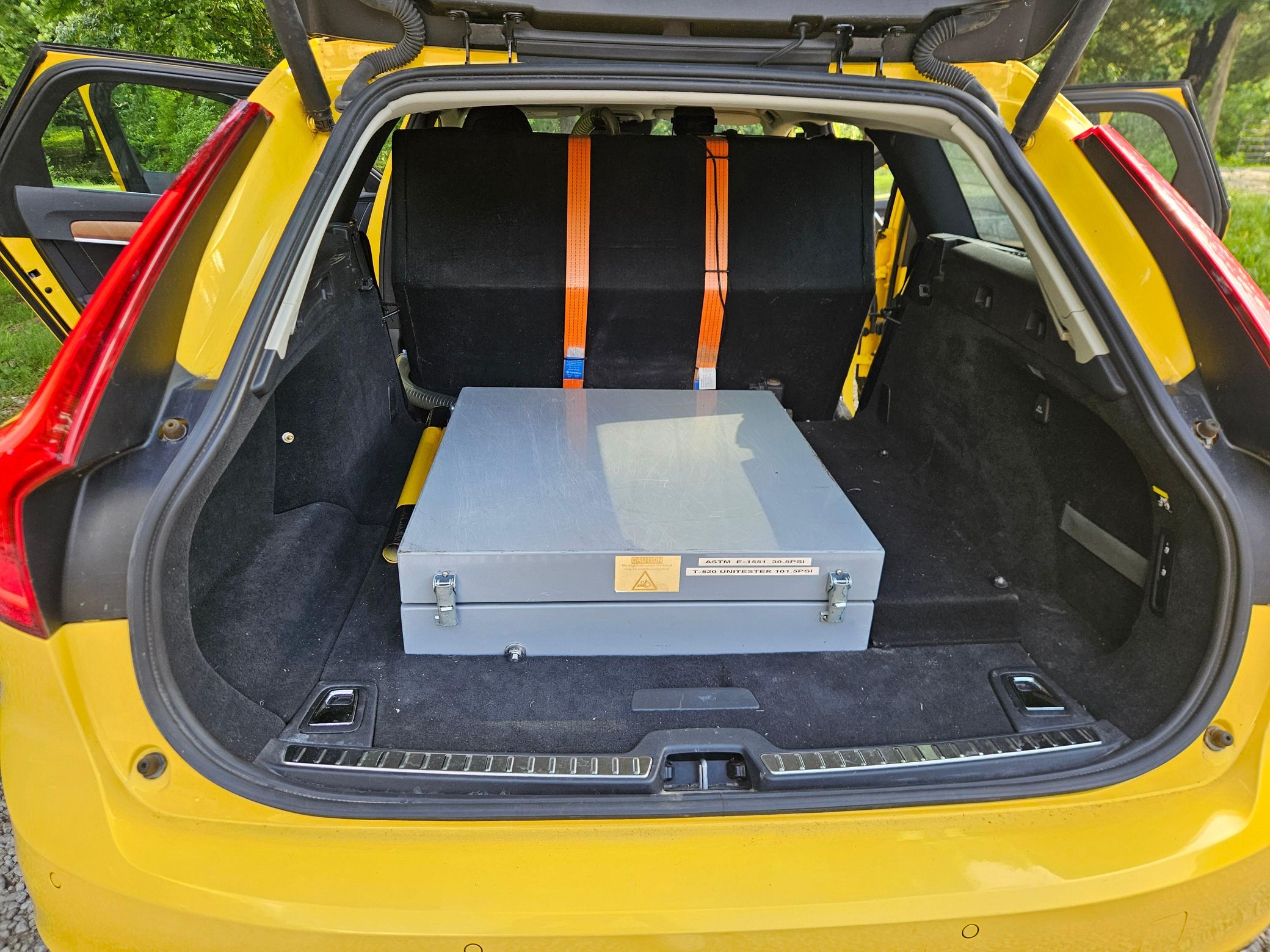 Yellow Volvo V90 with SARSYS airport runway friction testing equipment