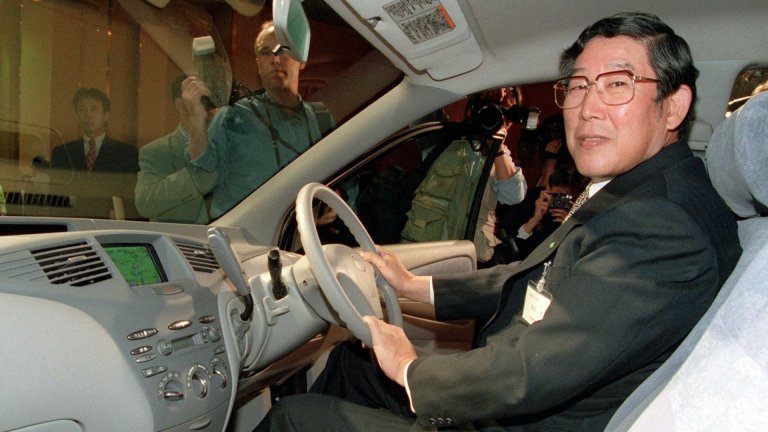 Hiroshi Okuda, President of Japan's Toyota Motor Corp., sits in the driver's seat of the newly developed "Prius", a passenger vehicle powered by the highly advanced Toyota Hybrid System, during a press introduction at a hotel 14 October. The Toyota Hybrid Ststem utilizes a gasoline engine and an electric motor as motive power sources. The Prius will be on sale 10 December with a price of 2.15 million yen (17,769 dollars). AFP PHOTO (Photo by KAZUHIRO NOGI / AFP)