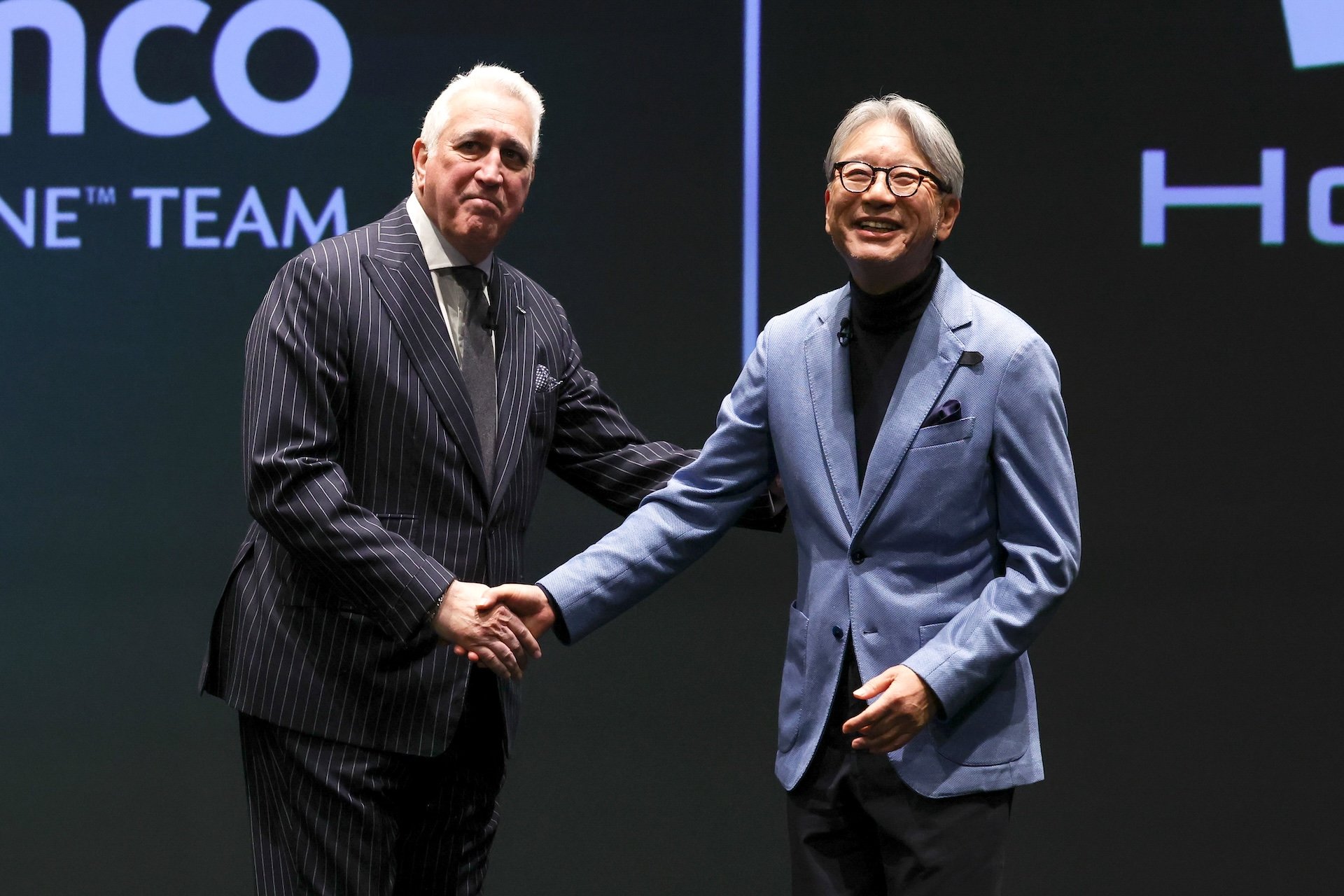 TOKYO, JAPAN - JANUARY 20: Executive Chairman of Aston Martin Aramco Formula One Team Lawrence Stroll (L) shakes hands with Honda Motor Co. CEO Toshihiro Mibe during Honda x Aston Martin Aramco Formula One team launch on January 20, 2026 in Tokyo, Japan. (Photo by Takashi Aoyama/Getty Images)