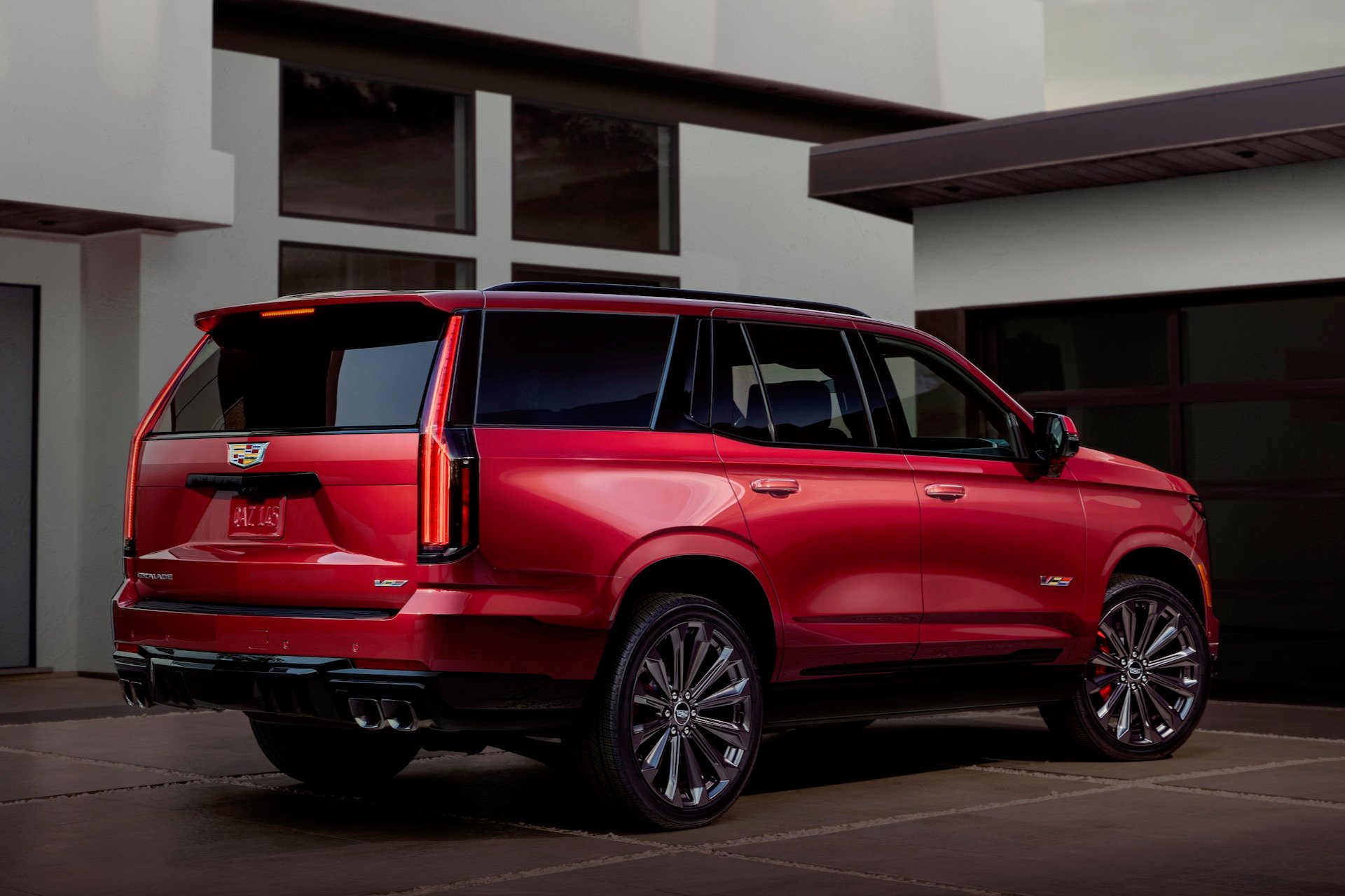 Rear ¾ view of the 2025 Cadillac Escalade-V, with a house in the background.
