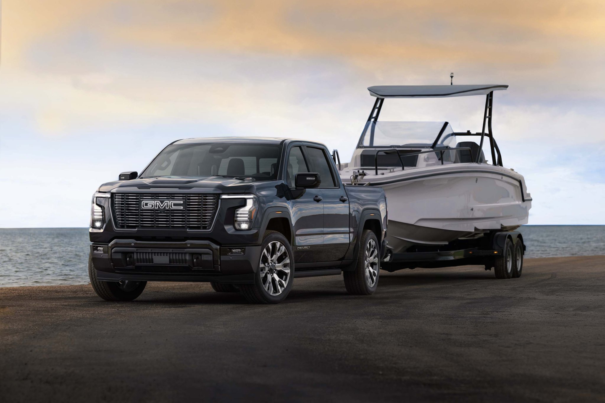 2027 GMC Sierra 1500 Denali Ultimate in Dark Ridge Metallic towing a boat. Exterior 3/4 shot. Preproduction model shown. Actual production model may vary.