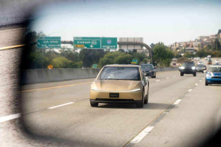 Tesla Cybercab seen in rearview mirror on California highway