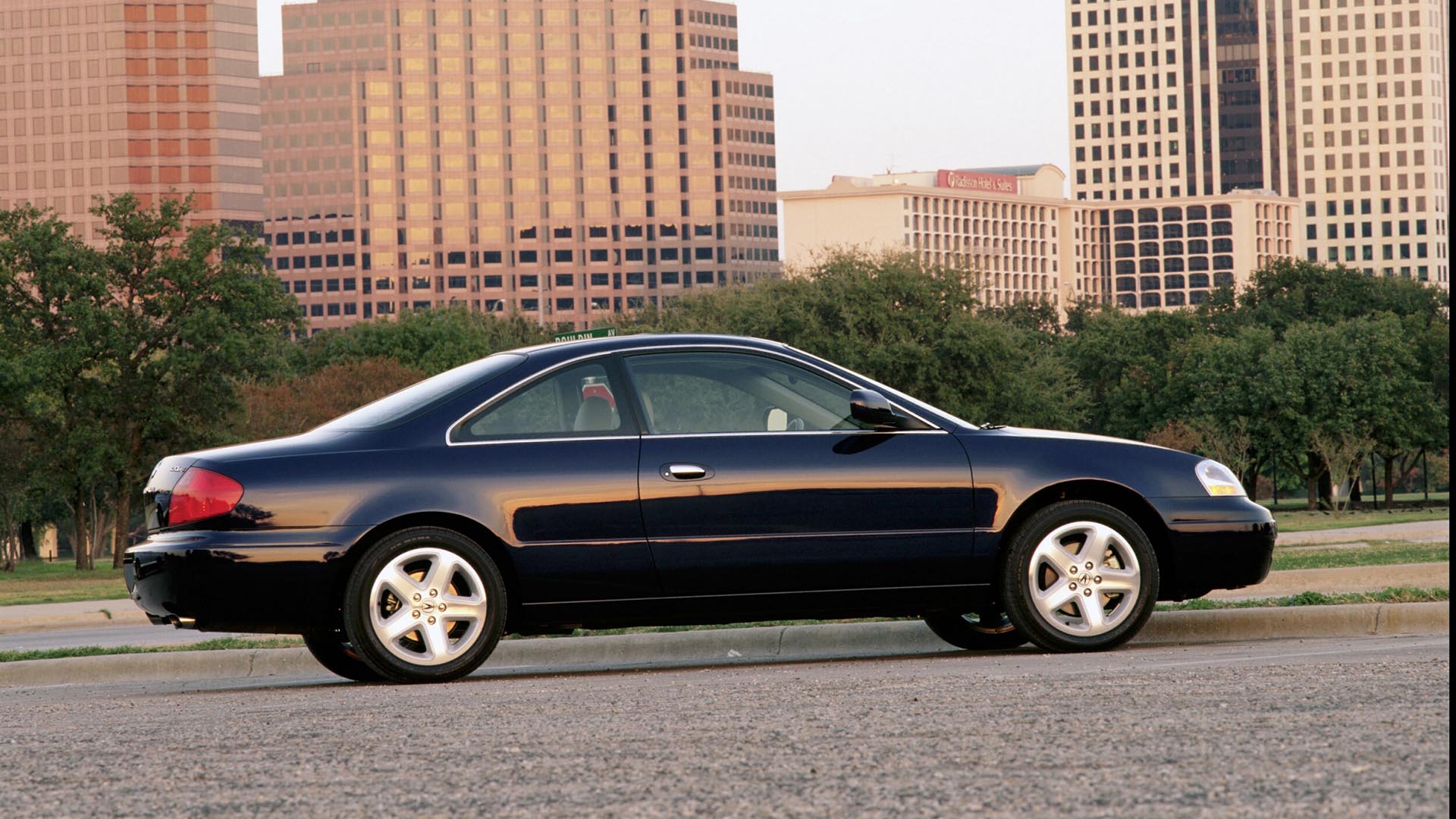 A dark 2001 Acura 3.2CL Type S parked in front of a skyline.