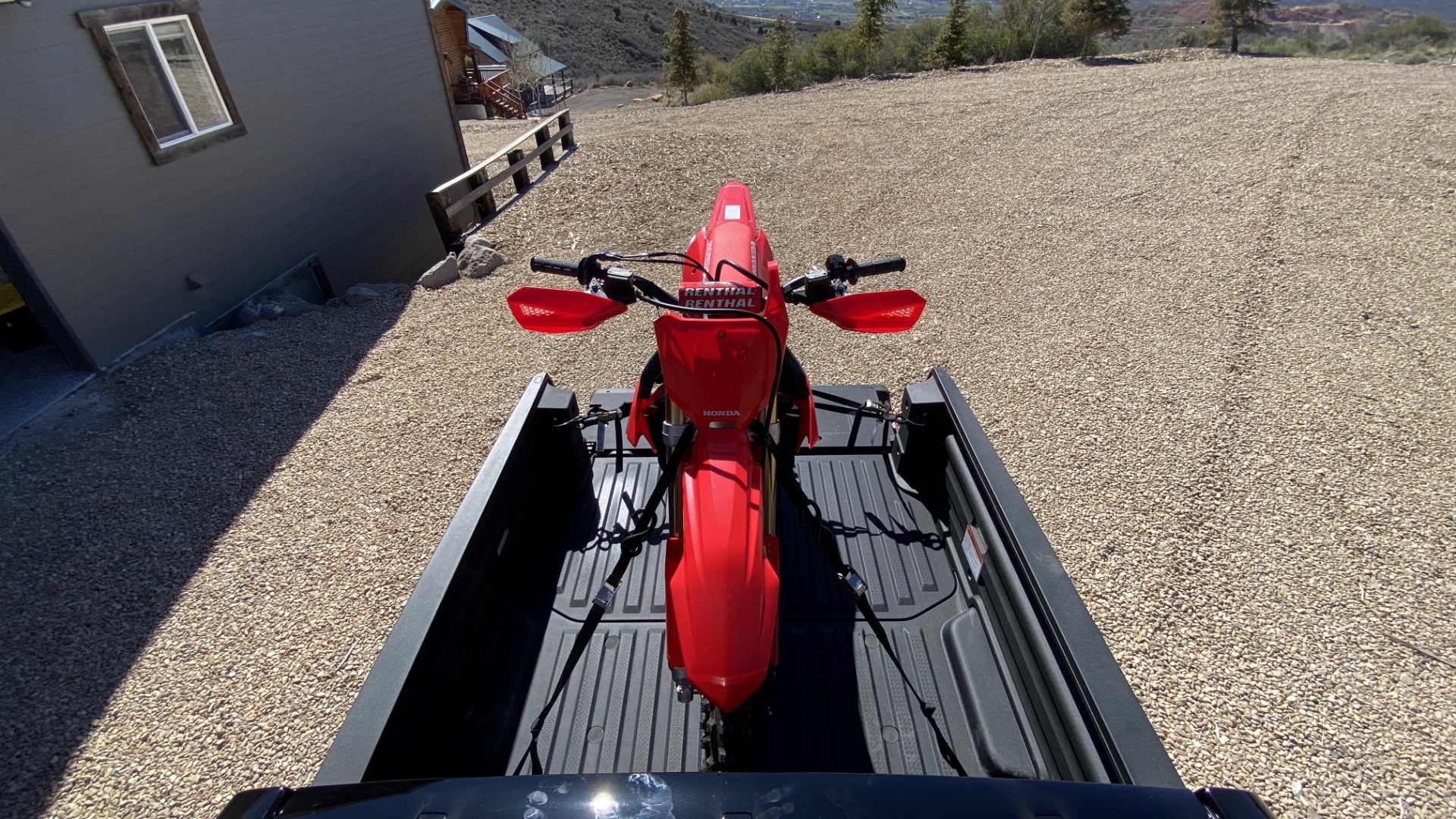 A red CRF450RX in the bed of a 2021 Honda Ridgeline.