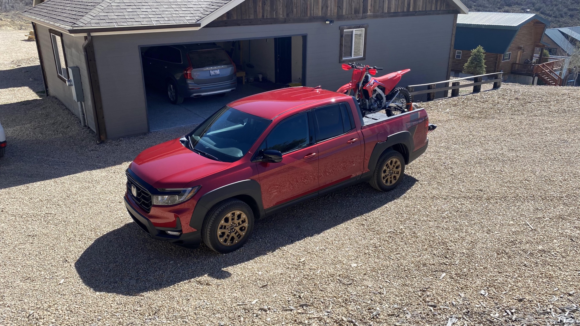 A red CRF450RX in the bed of a 2021 Honda Ridgeline.