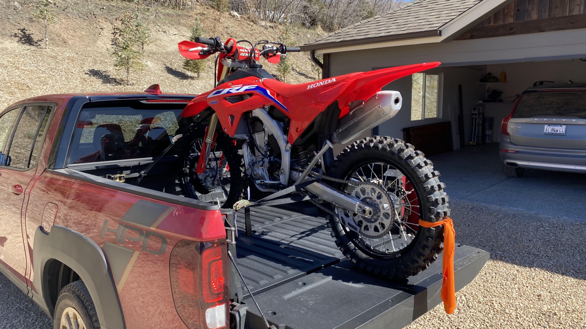A red CRF450RX in the bed of a 2021 Honda Ridgeline.