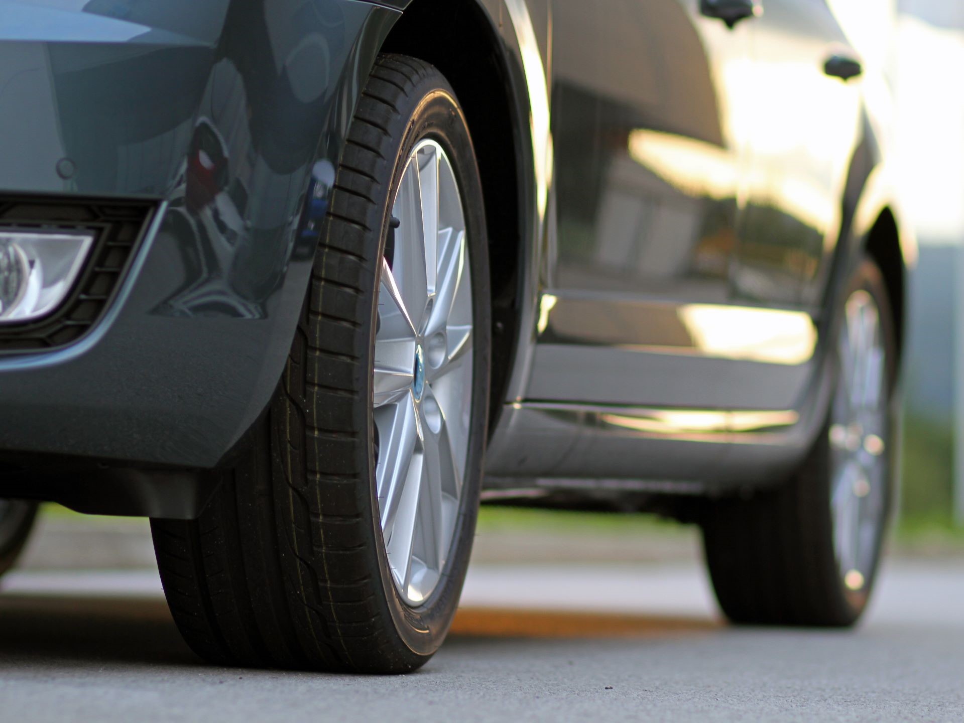 A ground-level view of the driver's side of the car, including the front and rear tires.