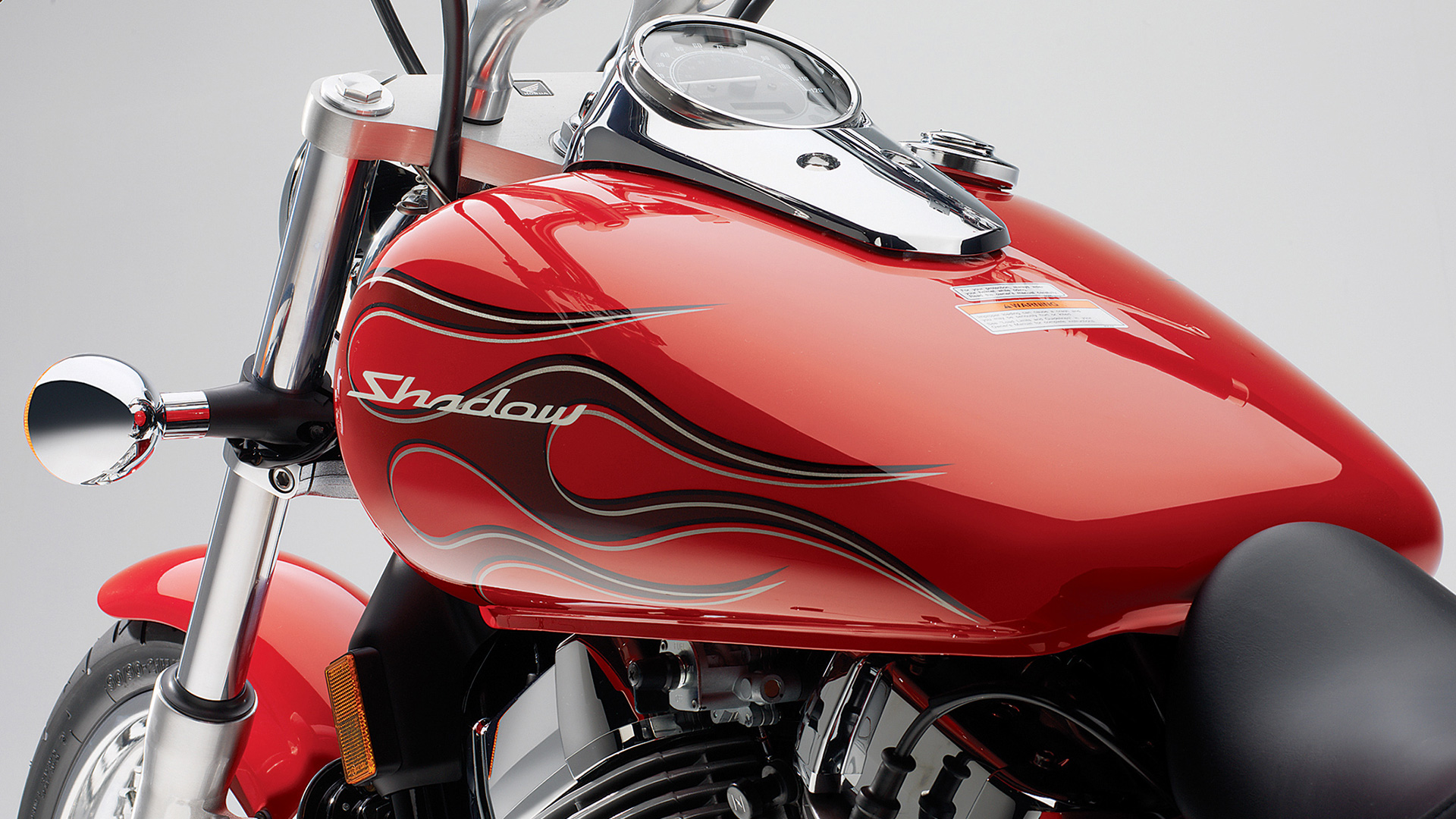 A Honda Shadow Spirit with a red gas tank with flames.