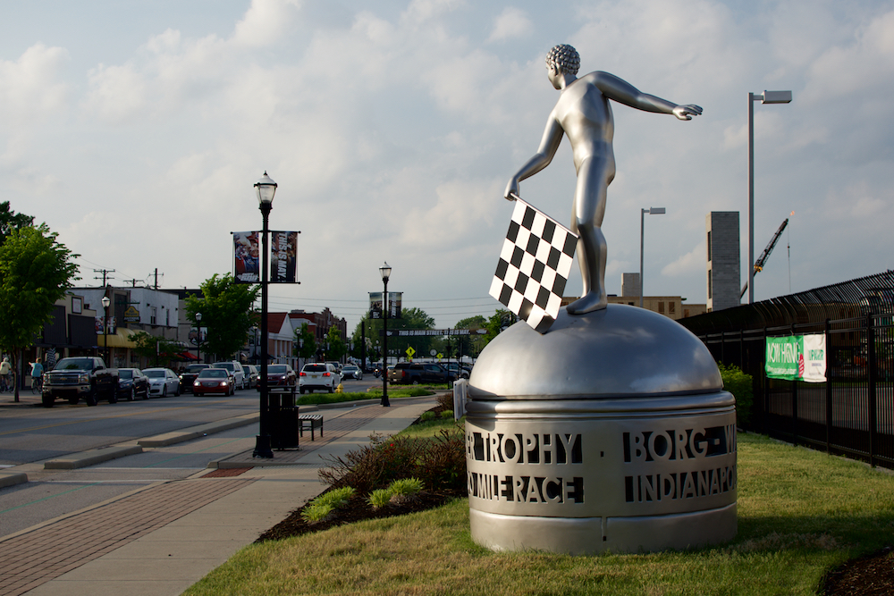 A car-sized replica of the BorgWarner Trophy welcomes fans.